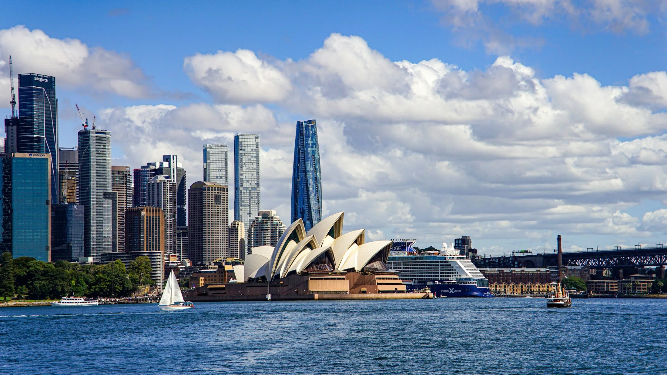 Sydney Opera House and harbour beneath a blue sky